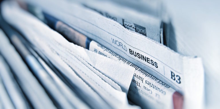 a stack of world business newspappers