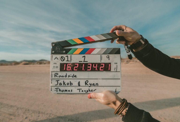 hands holding a filming clap board in the desert