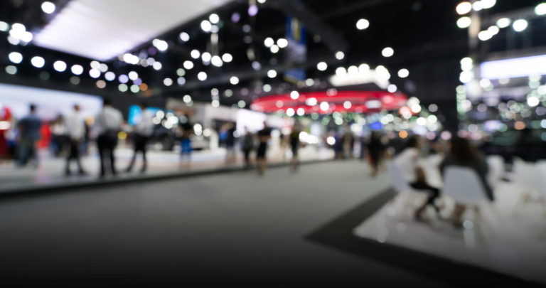 blurry trade show floor image of people moving around