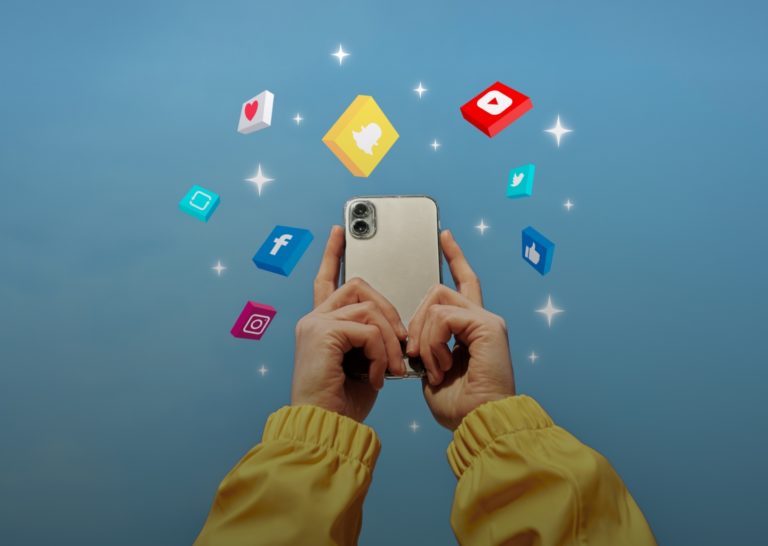 Hands holding up a smart phone surrounded by icons for all the different social media platforms.